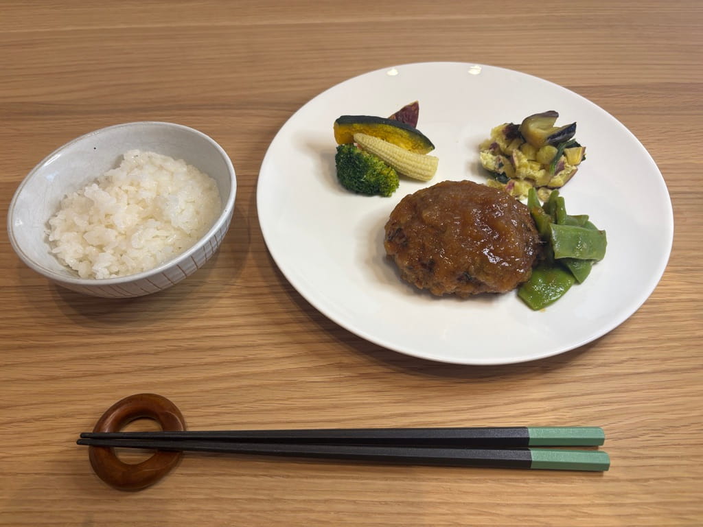 ご飯とお皿に盛り付けたグリーンスプーンのハンバーグ